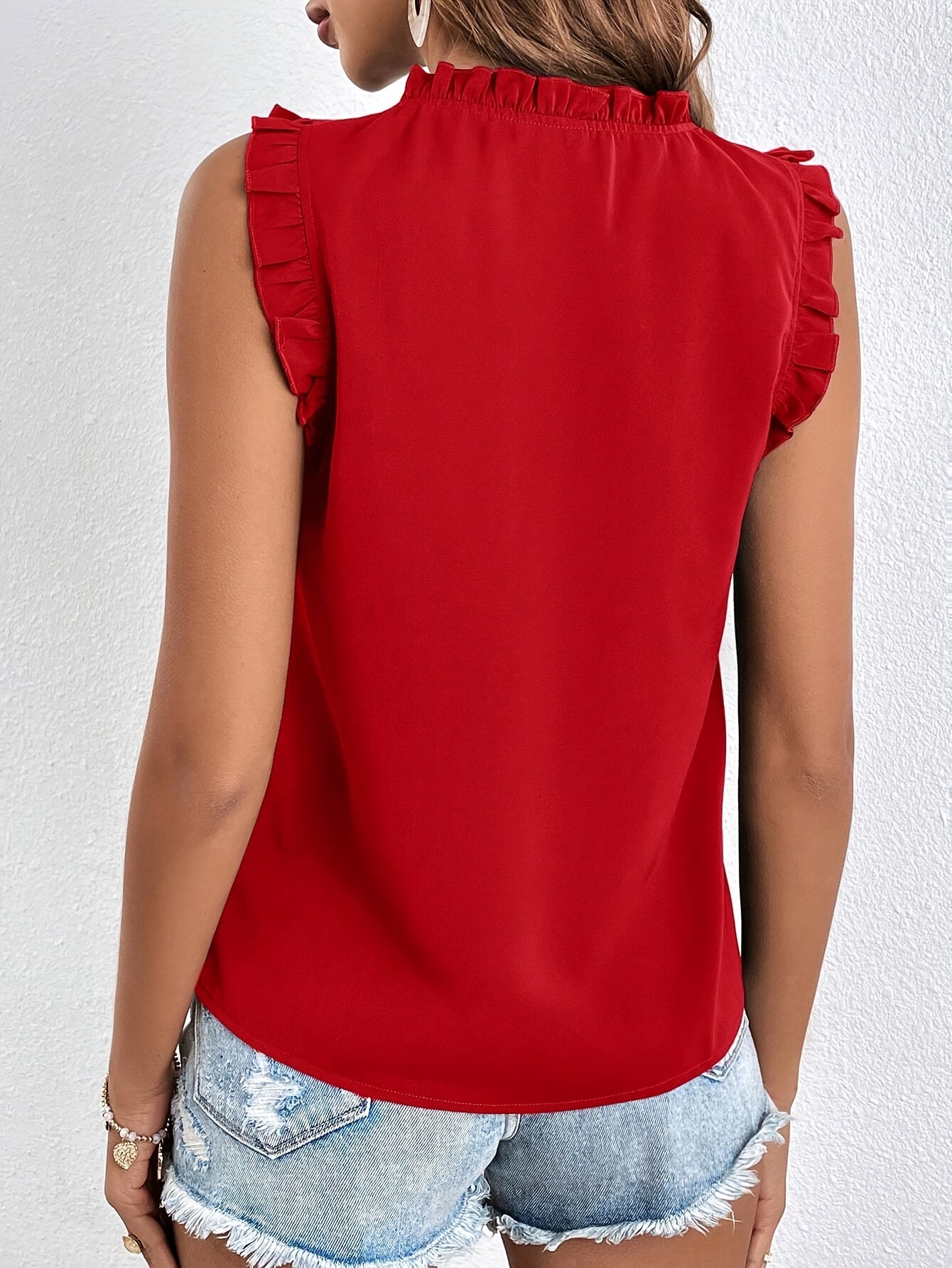 Women's sleeveless blouse with a ruffle at the neckline and tie