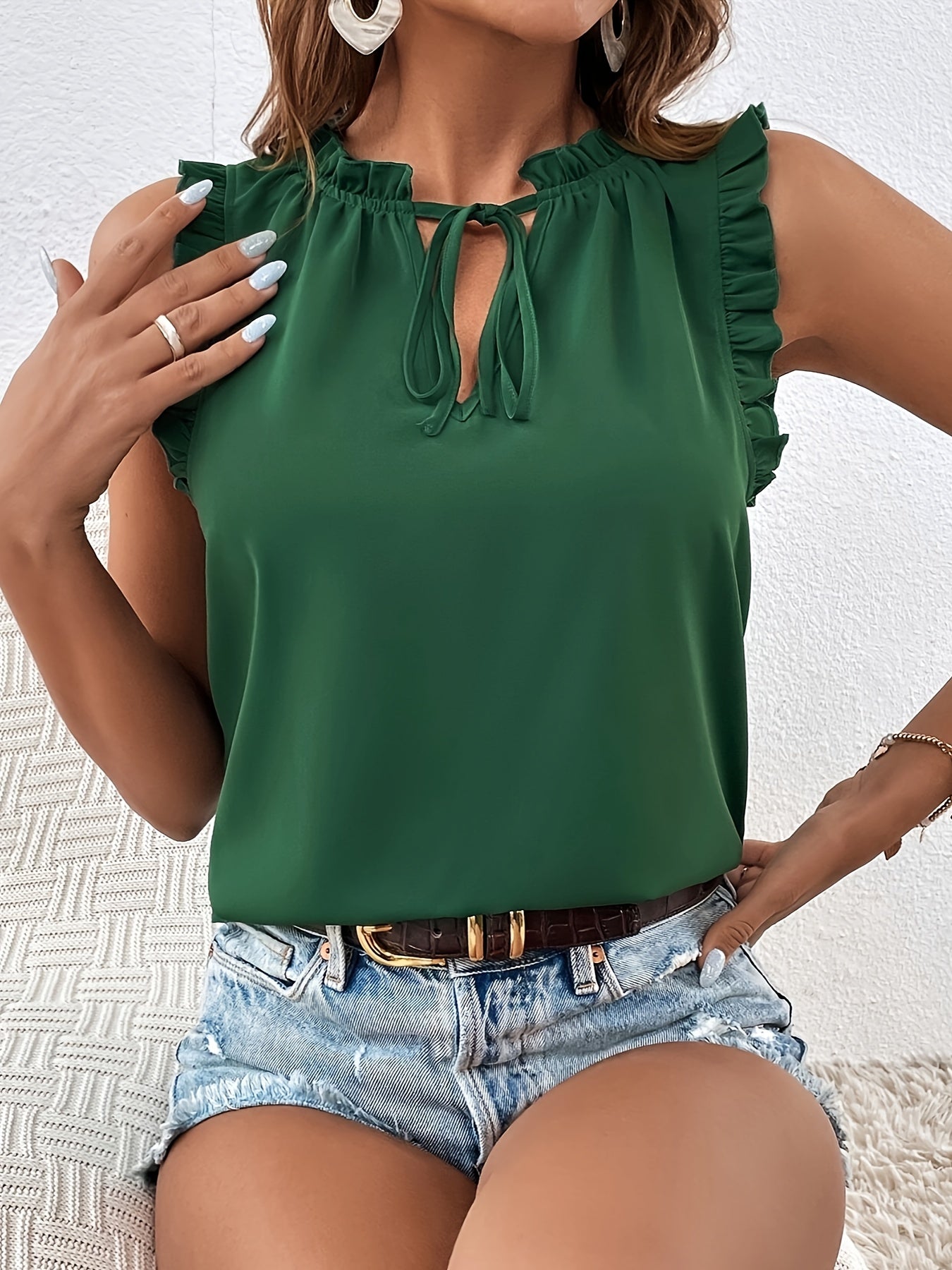 Women's sleeveless blouse with a ruffle at the neckline and tie